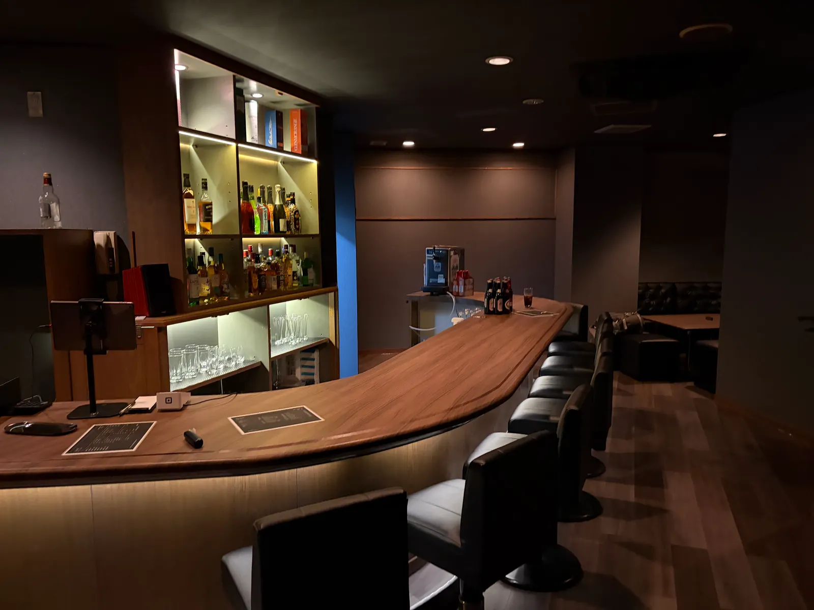 bar KURAXの木目のカウンターと黒いカウンターチェア