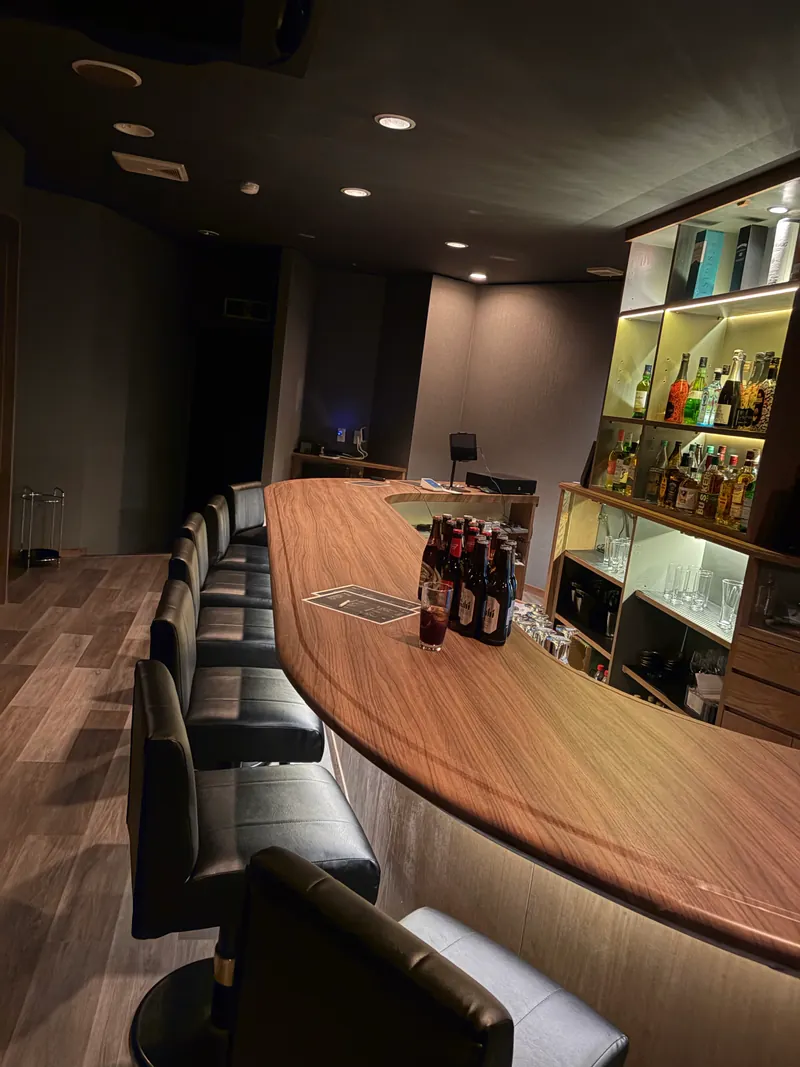 bar KURAXのカウンターとボトル棚を奥側から見た様子